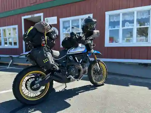 Lucia the Ducati Scrambler packed with luggage outside a store. Note: image is hyper-compressed with javascript disabled.