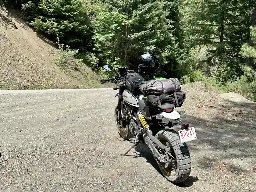 Lucia with her lil' bike backpack in July 2023. Since then I've added saddlebags to bring my total waterproofed luggage capacity to 84 litres. Note: image is hyper-compressed with javascript disabled.